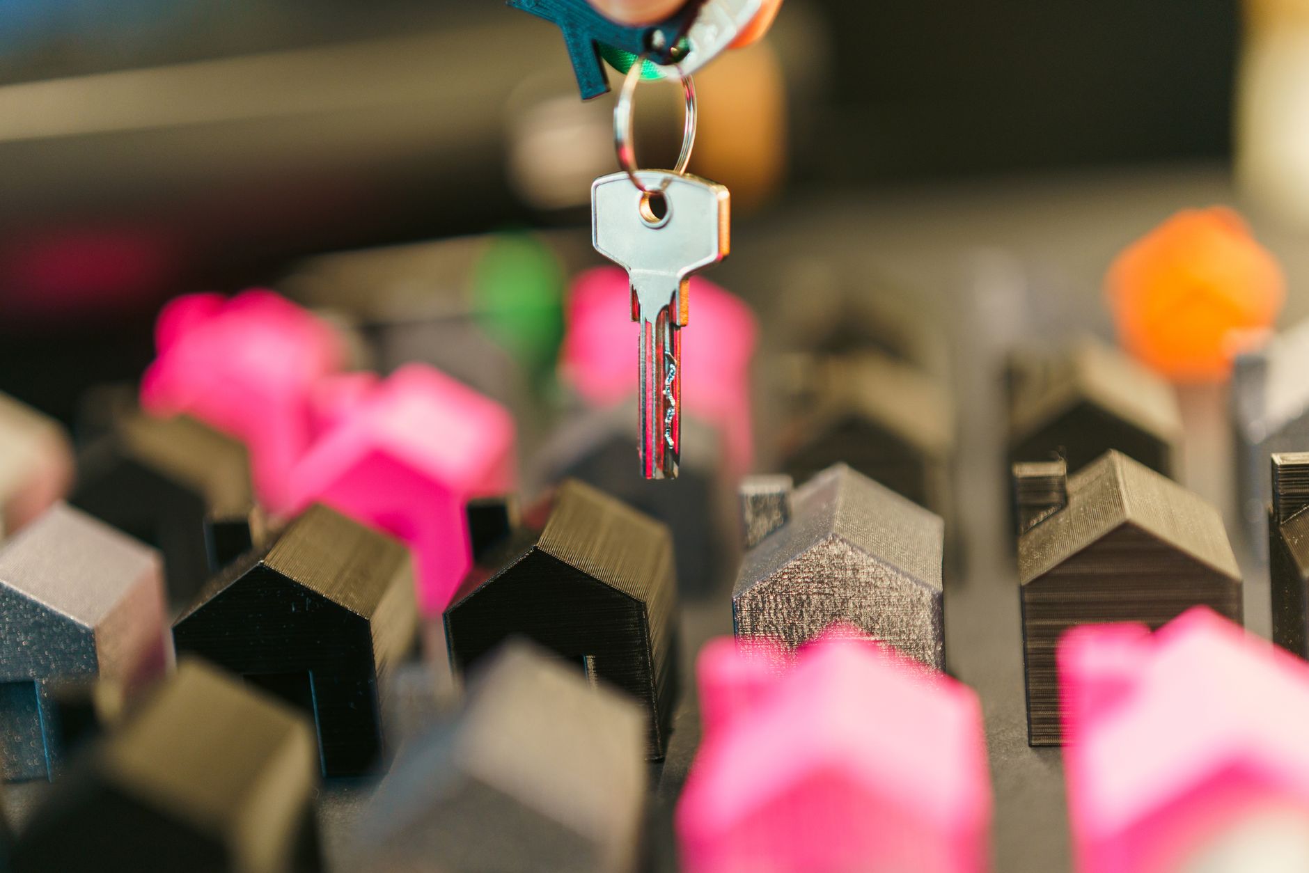 key to new home over miniature houses