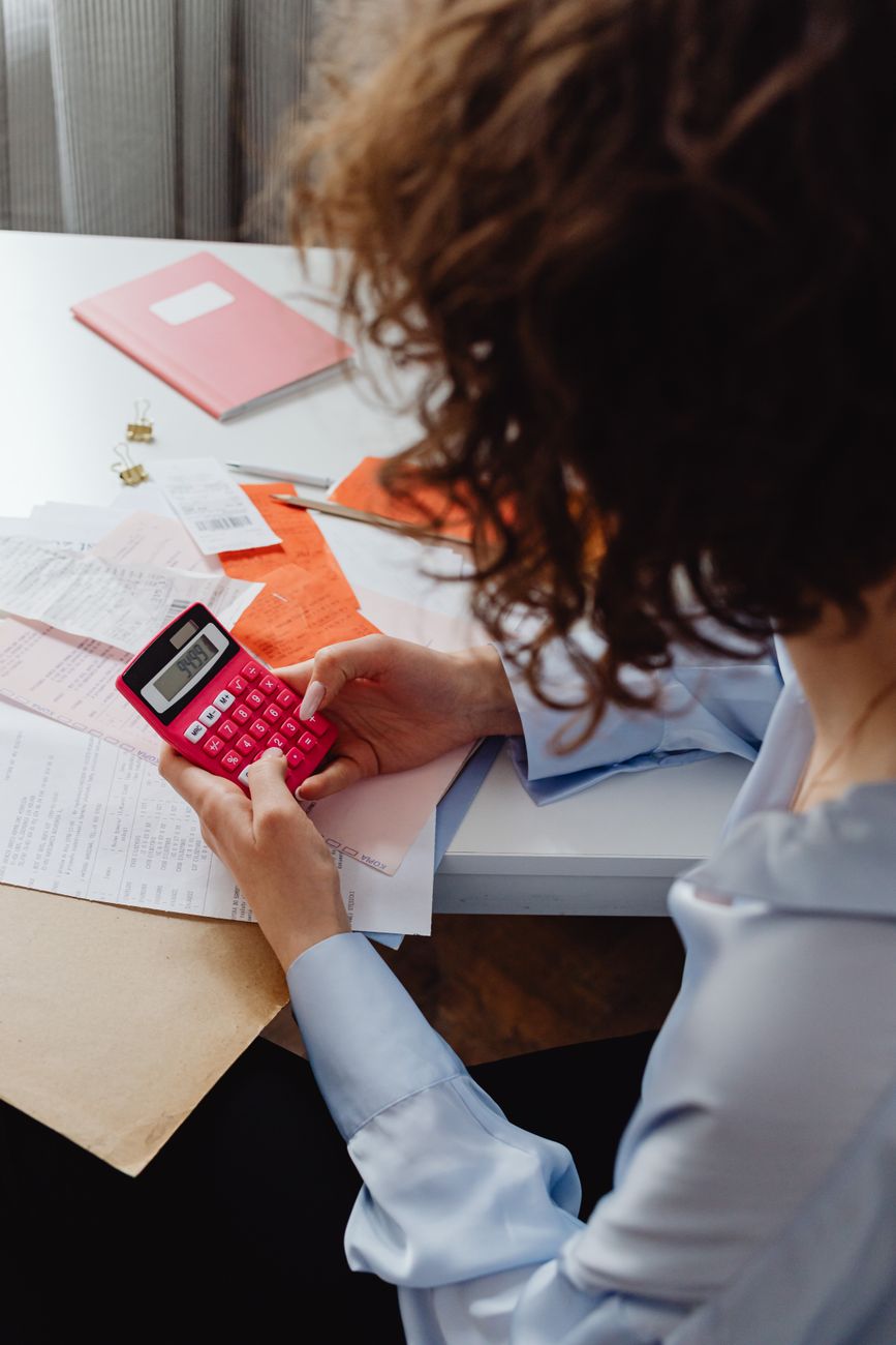 high angle shot of a person holding a calculator